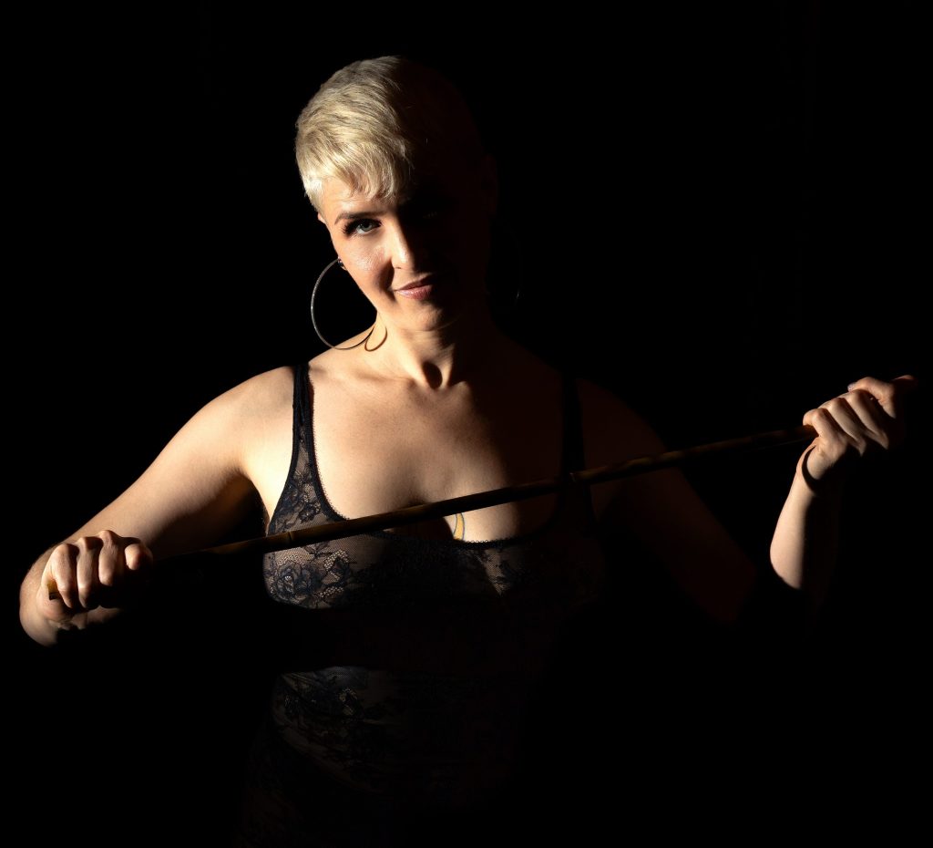 Queen Emma with a cane, half illuminated and half in shadow